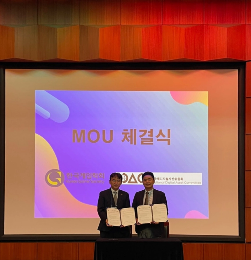 한국게임학회 윤태복 회장(좌측)과 국제디지털자산위원회(IDAC) 원은석 이사장(우측)이 협약서를 들고 기념촬영을 하고 있다.